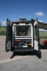 Rear view of an RV rental camper van, doors open to reveal custom organized storage. Ready for your next outdoor adventure.