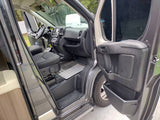 Detailed view of an RV rental's spacious cabin, showing the driver's seat, dashboard, and open passenger door.