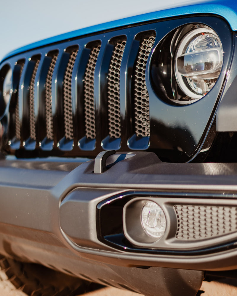 Front view of a blue Jeep SUV, featuring its iconic grille and round headlight. Great for outdoor trips; explore rv rental. — photo 19