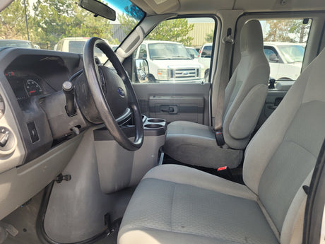 Interior of a Ford van, ideal for rv rental, showing driver's and passenger seats, steering wheel, and dashboard.