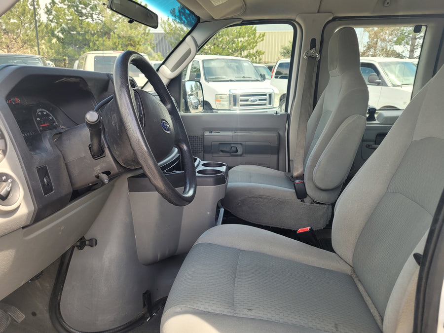 Interior of a Ford van, ideal for rv rental, showing driver's and passenger seats, steering wheel, and dashboard.