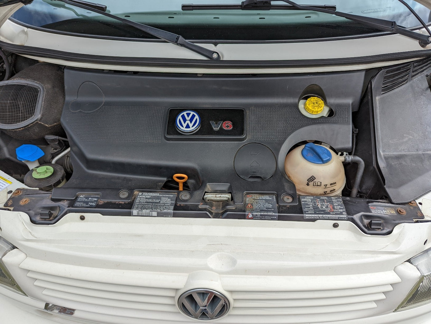 Volkswagen V6 engine bay of an RV rental, showing coolant, oil, and brake fluid reservoirs for maintenance. — photo 7