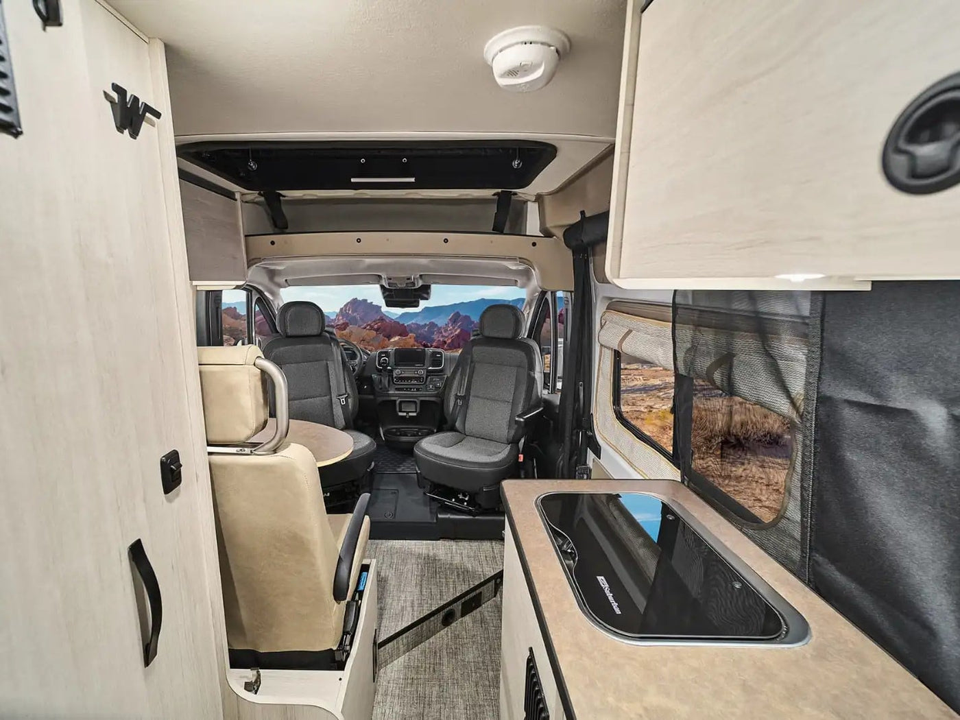 surrounded by tall green trees and rocks under a clear blue sky.|Spacious RV rental interior — photo 4