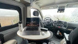 Cozy rv rental mobile office: laptop, Hydro Flask, and a rainy coastal view. Ideal for remote work & van life adventures.