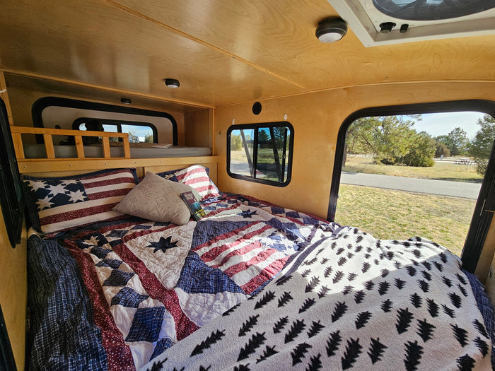  and a window view of nature.|Cozy RV rental interior featuring two comfortable beds