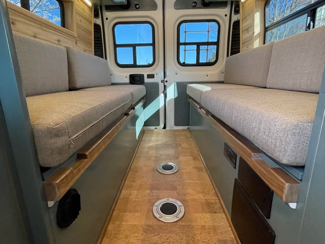 Clean RV rental interior with cozy bench seating/beds on both sides