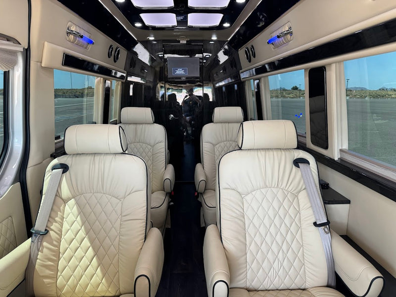 Spacious RV rental interior with luxurious cream-quilted leather captain's chairs, central aisle, and large windows. — photo 8