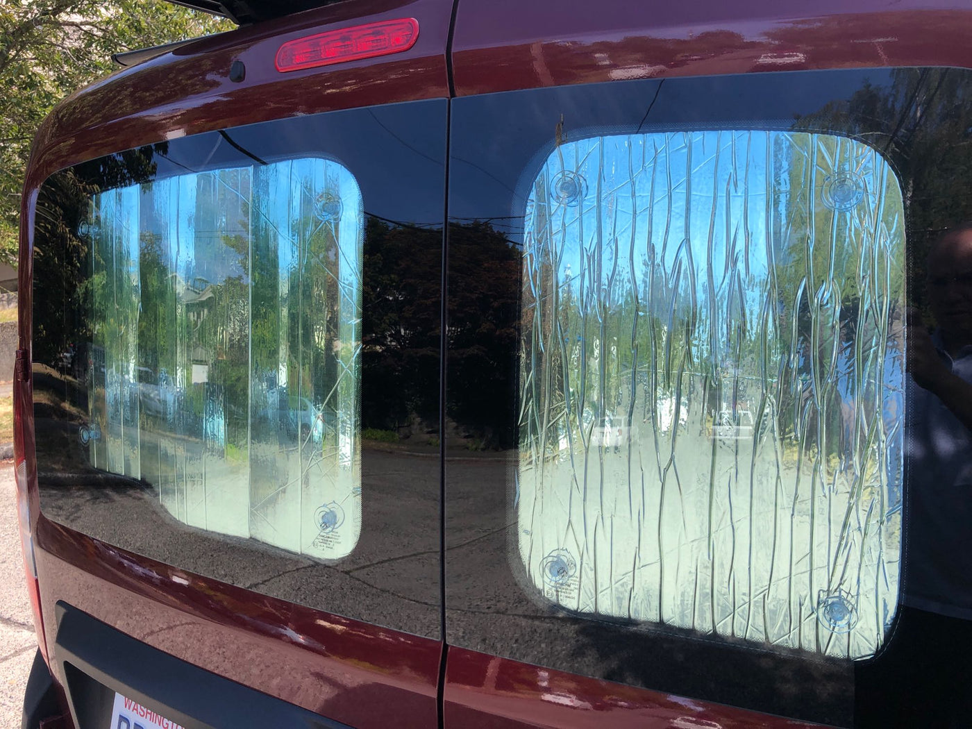 Rear view of an RV rental van showing custom reflective window insulators held by suction cups, ideal for temperature control. — photo 7