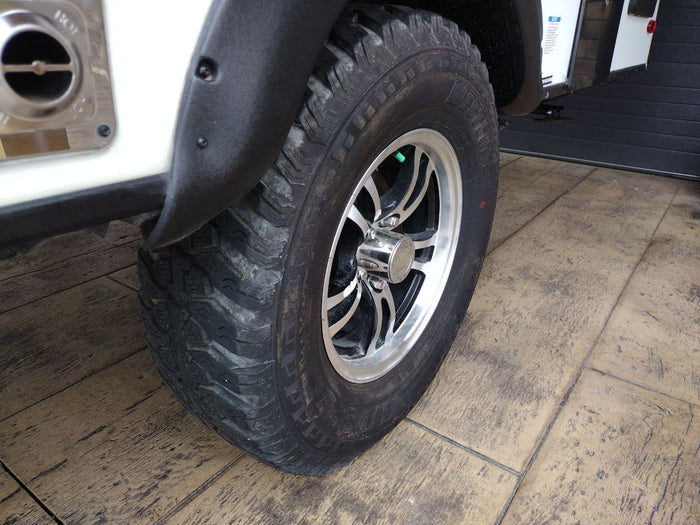  is ready for an RV rental.|RV rental: Close-up of a durable tire with a distinctive silver wheel and black fender flare