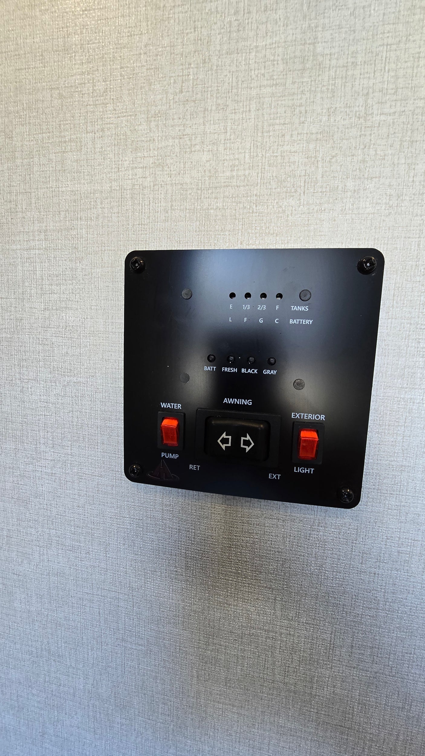 RV rental control panel displaying tank levels (fresh, black, gray), battery, water pump, awning controls, and exterior lights.