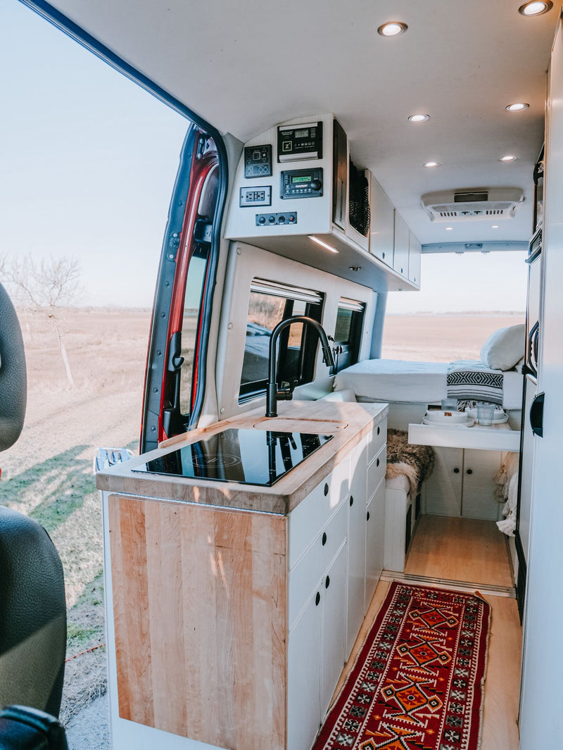  and a dog enjoying the scenic outdoor view. Perfect for a road trip adventure!|Enjoy nature from your RV rental! Cozy camper van interior with a comfortable bed — photo 9