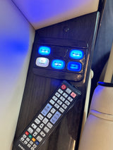 RV rental interior: illuminated control panel for lights and speakers, with a Samsung TV remote for entertainment.