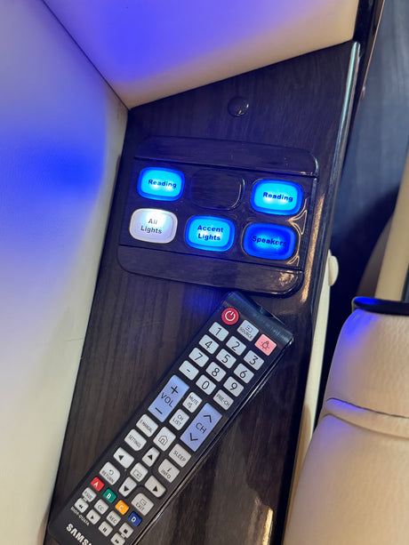 RV rental interior: illuminated control panel for lights and speakers, with a Samsung TV remote for entertainment.