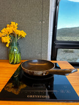 RV rental cooking station: Fresh daffodils, induction cooktop & pan. Perfect for mobile meals!