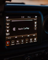 Vehicle infotainment screen in an RV rental setup shows Apple CarPlay, 7:19 time, 99°out, 70° cabin temp, and nav.