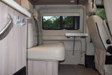 RV rental interior: comfy seating, versatile table, and large window. Perfect for your next camper van adventure.