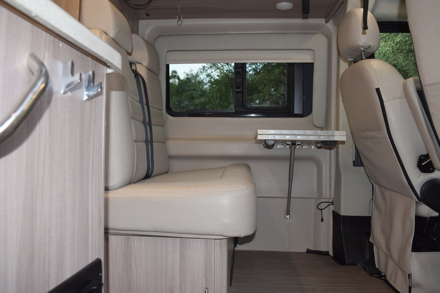 RV rental interior: comfy seating, versatile table, and large window. Perfect for your next camper van adventure.