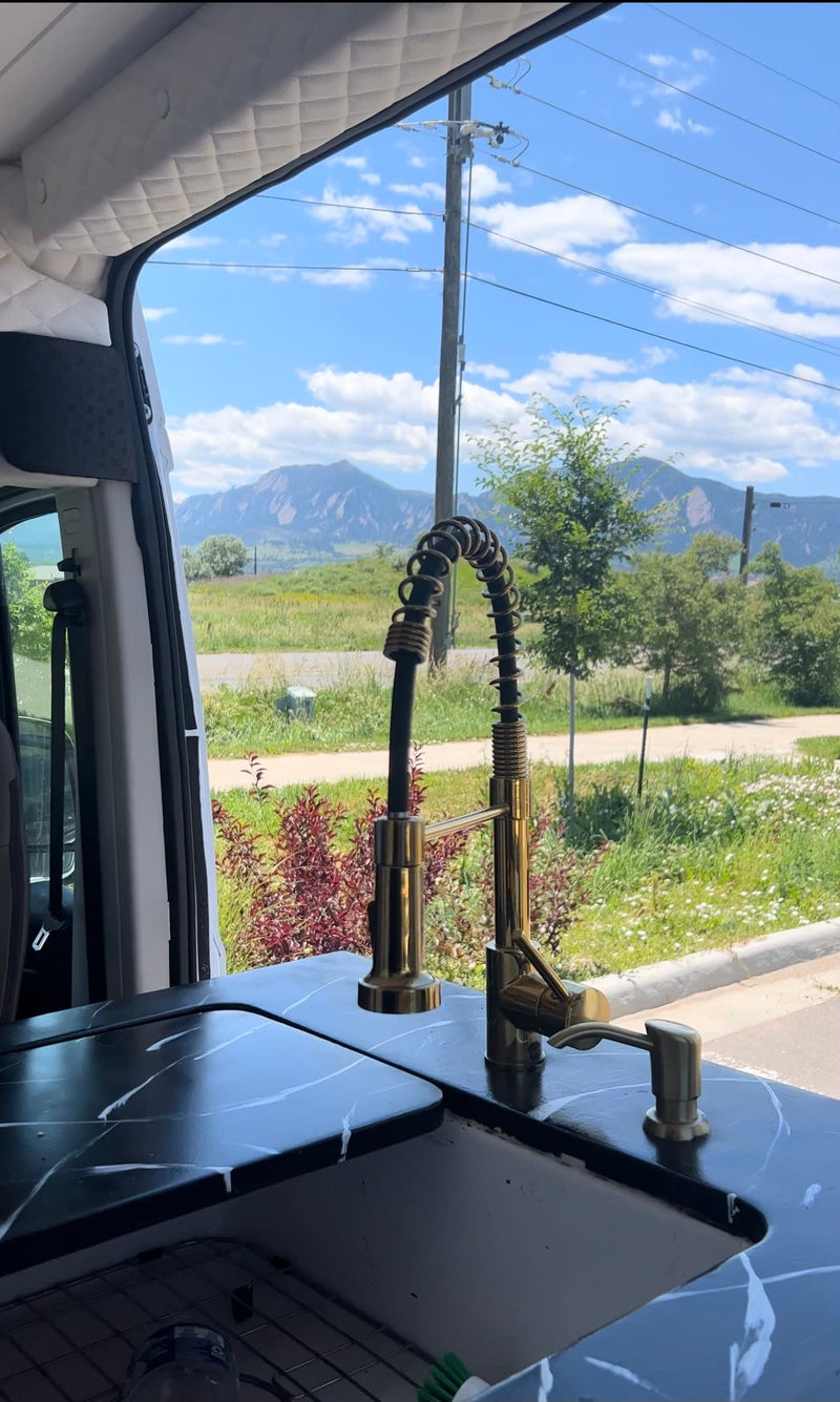 Stunning mountain views from an RV rental's modern kitchen setup. Enjoy van life with this sleek sink & faucet! — photo 7