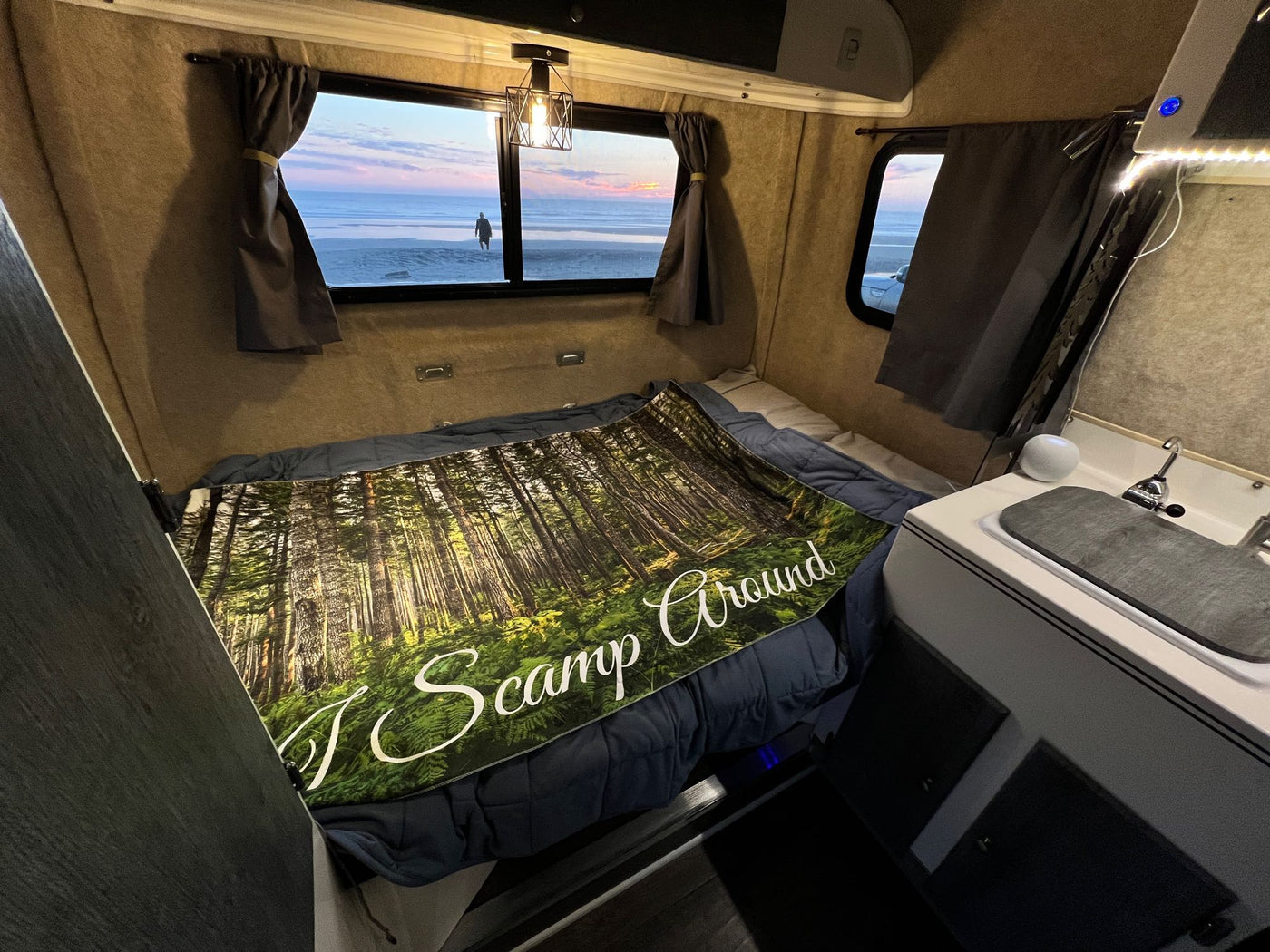 Cozy RV rental interior with a forest blanket and stunning beach view at sunset. Perfect for camping adventures. — photo 14