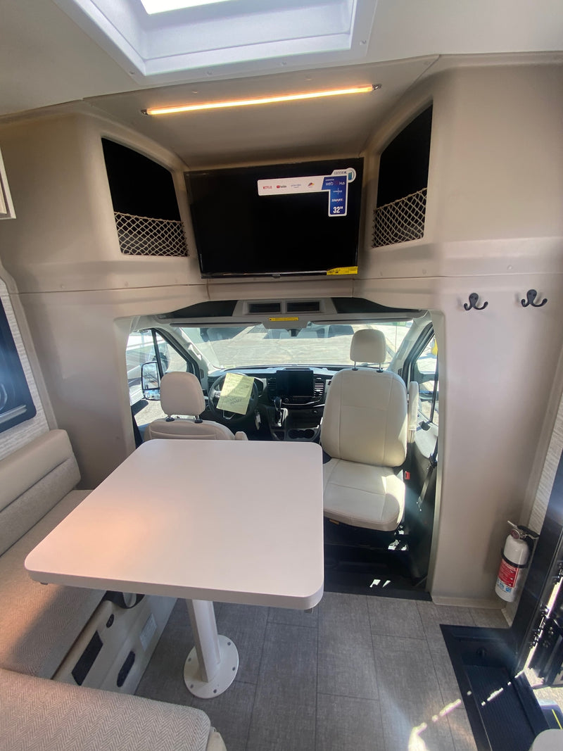  and large central touchscreen.|RV rental interior: View of the cockpit from the living area with TV — photo 6