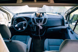This image displays the clean and functional front cabin interior of a Ford Transit RV rental van, ready for your next adventure.