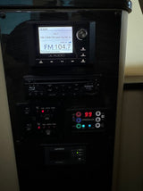 RV rental control panel shows JL Audio radio, Blu-ray, climate (99°F), & Xantrex power monitoring for passenger comfort.