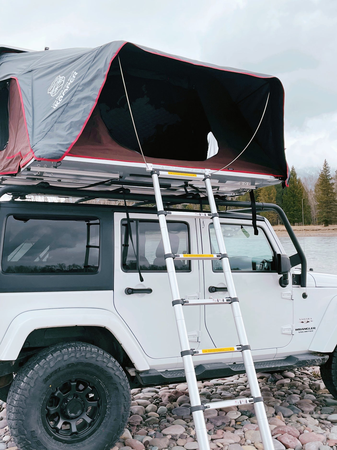 White Jeep Wrangler with iKamper rooftop tent & ladder, ready for your next adventure. A unique rv rental for overland camping.