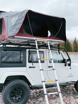 White Jeep Wrangler with iKamper rooftop tent & ladder, ready for your next adventure. A unique rv rental for overland camping.