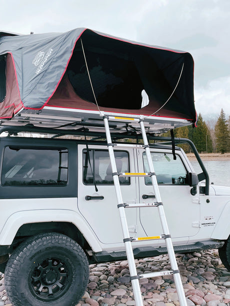 White Jeep Wrangler with iKamper rooftop tent & ladder, ready for your next adventure. A unique rv rental for overland camping.