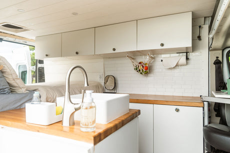 This rv rental shows a modern camper van interior with a compact kitchenette, bed, and smart storage for on-the-go living.