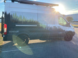 A sunlit Vandoit camper van, featuring a striking forest graphic, makes for an ideal RV rental. Ready for adventure!