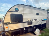 Well-maintained Clipper Coachmen travel trailer in white & grey, parked outdoors. Ideal for an rv rental.