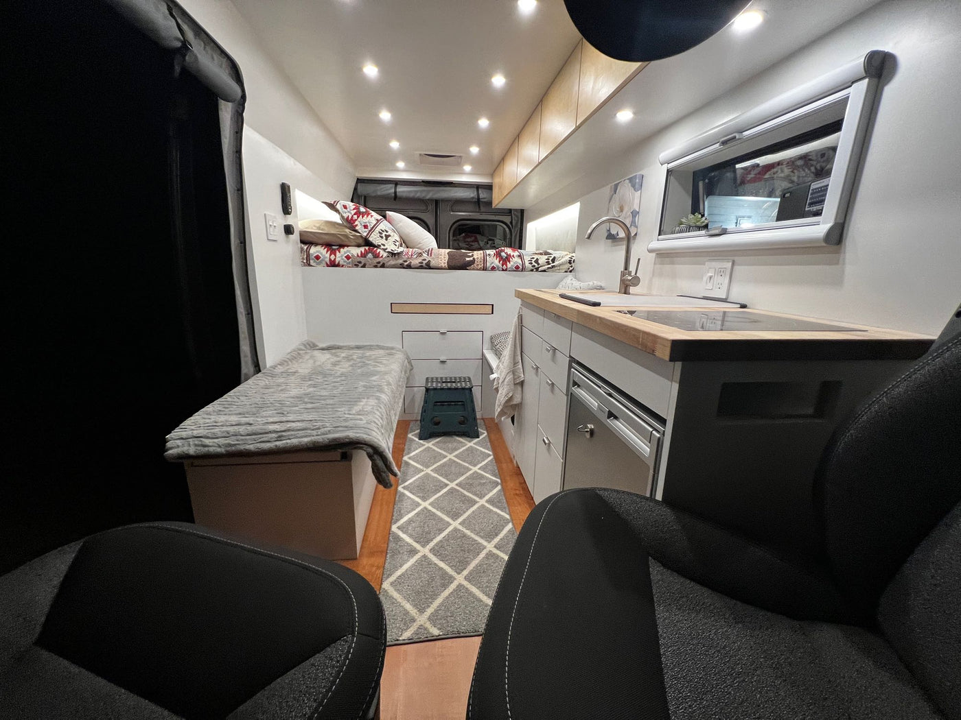  dark RV rental van rests on a scenic mountain road