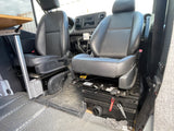 RV rental interior: View of swiveled front seats, dashboard, and a side table. Details show an organized mobile living space.
