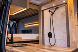 Explore this luxurious RV rental interior: modern kitchen, cozy bed, and stylish tiled shower. Ideal compact living.