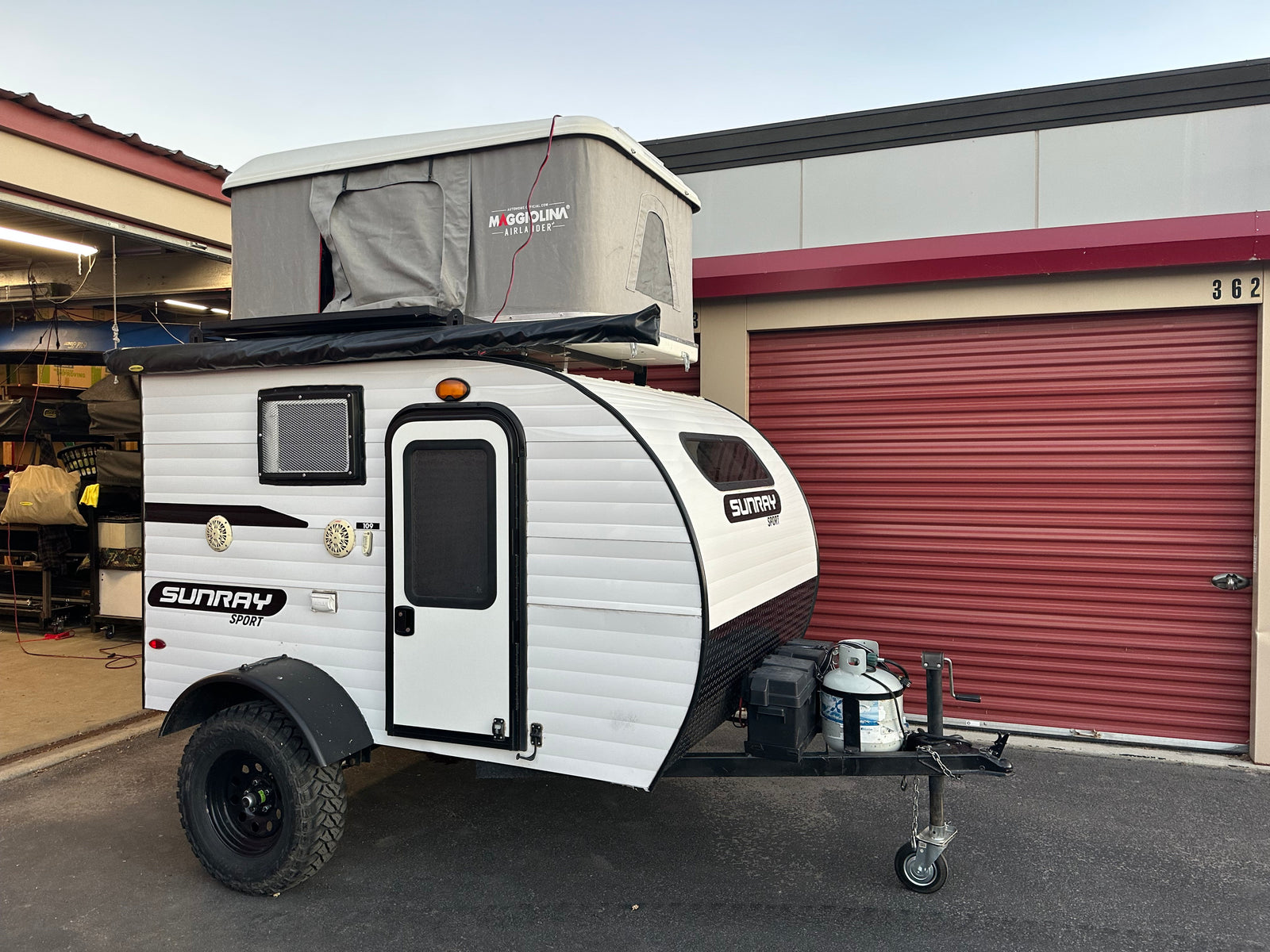 Explore with this white Sunray Sport teardrop camper, featuring a Maggiolina rooftop tent – perfect for an RV rental adventure!