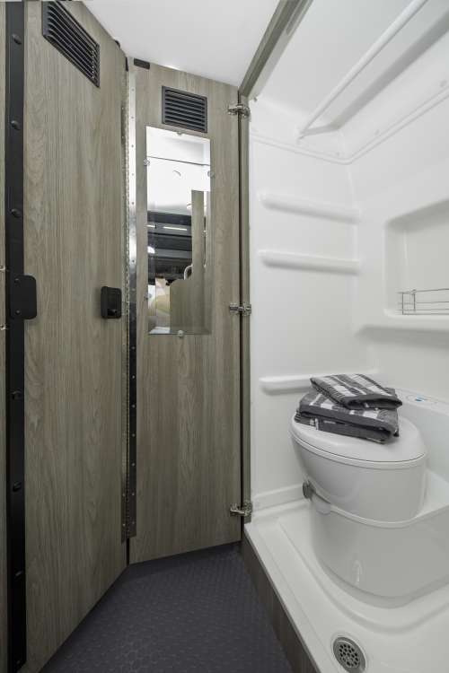  and rear windows with a nature view.|Compact camper van RV rental interior: bed — photo 10