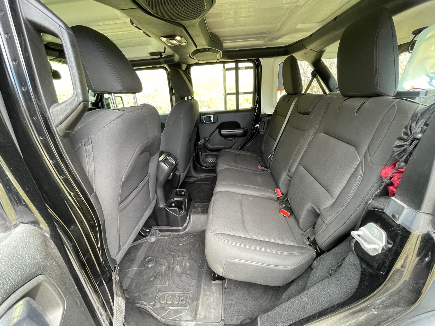 Spacious rear interior of a Jeep Wrangler, with black seats & all-weather floor mats. Ideal for an adventure rv rental. — photo 13