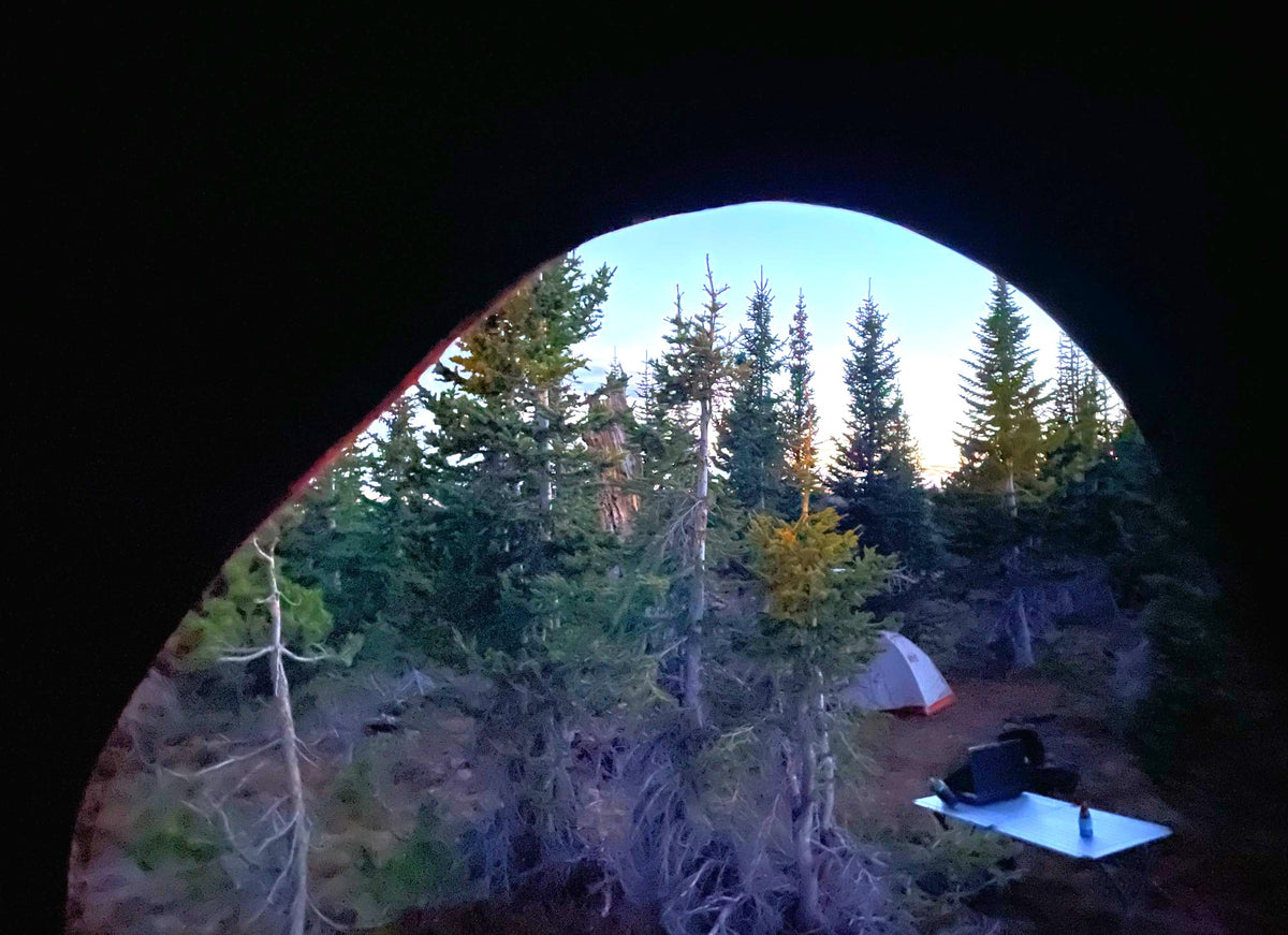 Sunrise from a tent at a peaceful forest campsite, another tent and gear seen. Perfect for your next rv rental adventure! — photo 15
