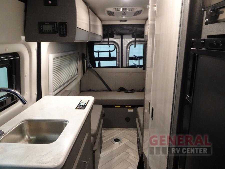 Spacious RV rental interior featuring a kitchen, bench seating, and compact living area for comfortable travel. — photo 5