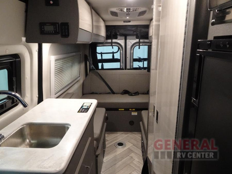Spacious RV rental interior featuring a kitchen, bench seating, and compact living area for comfortable travel. — photo 5