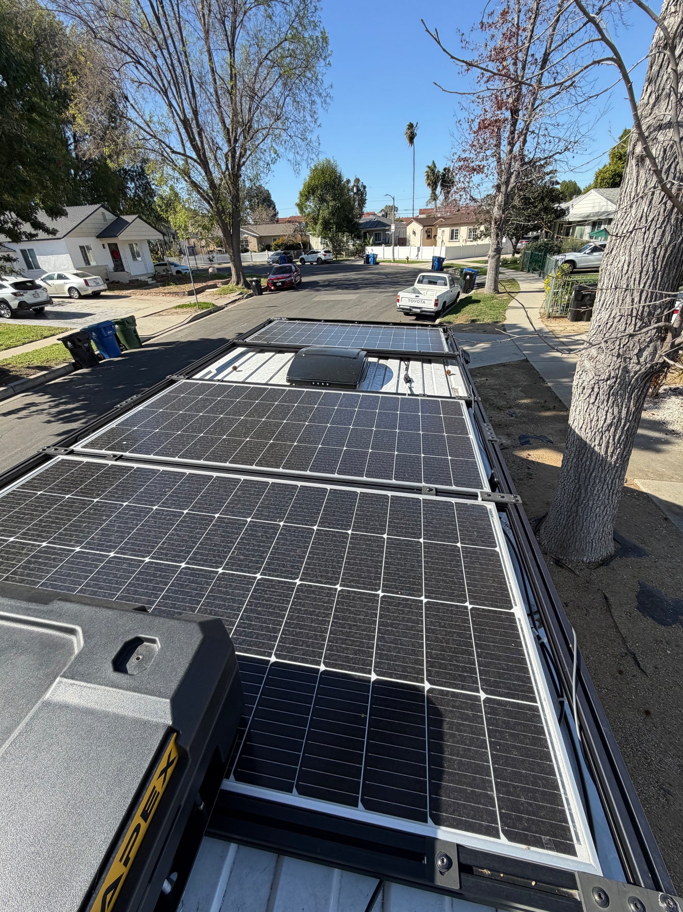 Rooftop solar panels on an RV rental parked on a residential street, providing off-grid power for adventures.