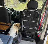 A happy dog relaxes inside a pet-friendly RV rental, showing the interior with swivel seats, storage, and a portable table.
