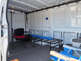 Inside this rv rental: a cargo van interior with a cot, chairs, and cooler, ready for camping adventures.