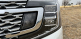 Rain-splashed grille and modern LED headlight of a large SUV. Perfect for your RV rental adventure.