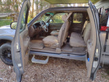 Open doors reveal the spacious beige interior of an adventure-ready truck, perfect for your next RV rental journey.