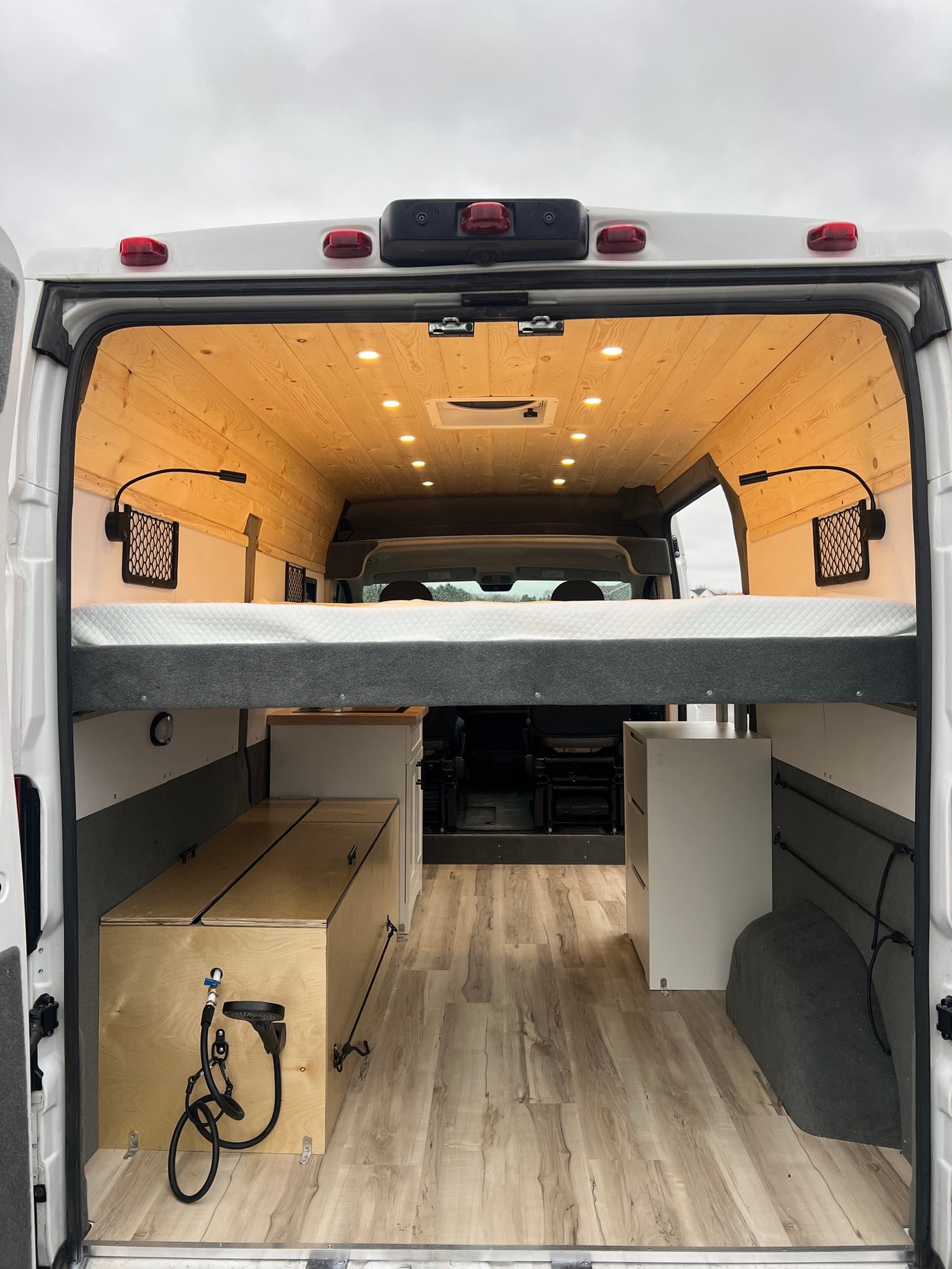  and ample storage for comfortable mobile living.|Cozy RV rental interior with raised bed — photo 8