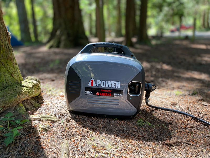 A portable Yamaha iPOWER generator sits on a wooded campsite floor, ideal for RV rental power. — photo 15