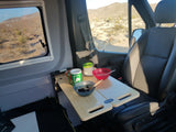 A cozy breakfast in an RV rental, featuring oatmeal and coffee on a table, with a desert mountain view outside.