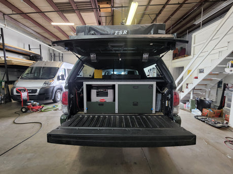 Rear of a custom overland truck with FSR rooftop tent, SnoMaster fridge, and storage system, ideal for an RV rental adventure.